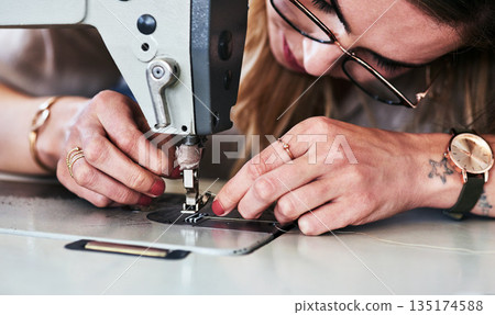Sewing machine, woman hands and creative fashion designer with button and thread work. Small business, entrepreneur and female tailor with boutique and employee working with machinery for clothing Sewing machine, woman hands and creative fashion designer with button and thread work. Small business, entrepreneur and female tailor with boutique and employee working with machinery for clothing 135174588