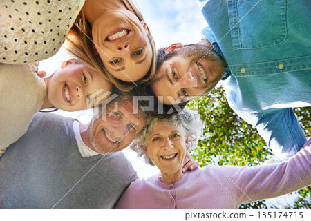 Face portrait, smile and circle of happy family hug, grandparents and parents bond with kid in nature park. Solidarity care, blue sky or bottom view of people smile in garden, forest or outdoor woods Face portrait, smile and circle of happy family hug, grandparents and parents bond with kid in nature park. Solidarity care, blue sky or bottom view of people smile in garden, forest or outdoor woods 135174715