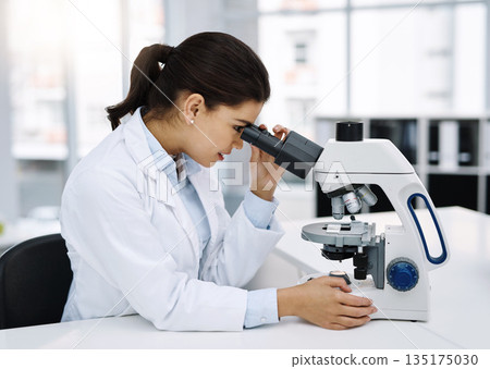Scientist, research and woman with microscope in laboratory for medical study. Professional, science and female doctor with scope equipment for sample analysis, particle test and lab experiment. 135175030