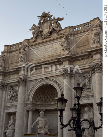 Close-up of historic Roman building with detailed sculptures, columns, and vintage street lamps in Rome, Italy. Close-up of historic Roman building with detailed sculptures, columns, and vintage street lamps in Rome, Italy. 135175083