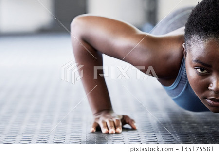 Portrait, focus and push ups with a black woman on the floor of a gym for exercise or fitness training. Face, half and mockup with a young female athlete doing a sports workout for strong muscles Portrait, focus and push ups with a black woman on the floor of a gym for exercise or fitness training. Face, half and mockup with a young female athlete doing a sports workout for strong muscles 135175581