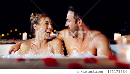 Spa, love and couple in a jacuzzi happy, smile and relax one date night at a wellness resort. Zen, hot tub and man with woman laughing, peace and enjoying a romantic vacation, holiday or anniversary 135175584