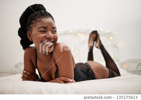 Happy, sexy and a black woman in lingerie on a bed, thinking and ready for the night. Smile, ideas and an African girl in the bedroom in seductive underwear for confidence, happiness or sensuality 135175613