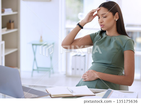 Stress, pregnant woman in office with headache at desk and small business research online with laptop. Pregnancy, exhausted businesswoman and working overtime on report for startup design company. Stress, pregnant woman in office with headache at desk and small business research online with laptop. Pregnancy, exhausted businesswoman and working overtime on report for startup design company. 135175636