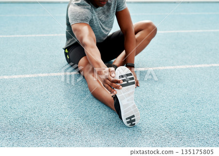 Athlete, sitting and track for stretching legs to start training, exercise or running for fitness outdoor. Man, runner and warm up for muscle, body and wellness at stadium for race, contest or sports Athlete, sitting and track for stretching legs to start training, exercise or running for fitness outdoor. Man, runner and warm up for muscle, body and wellness at stadium for race, contest or sports 135175805