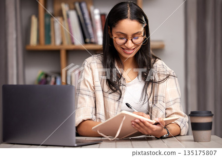 Laptop, writing and education with a student woman in a university library to study for a final exam. Technology, learning and notebook with a young female college pupil reading research material 135175807