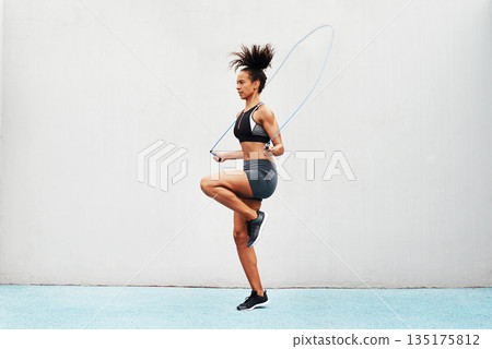 Jump, skipping rope and training with woman in stadium for sports, workout practice and cardio. Performance, health and body with female athlete jumping on track for strong, mockup space and exercise Jump, skipping rope and training with woman in stadium for sports, workout practice and cardio. Performance, health and body with female athlete jumping on track for strong, mockup space and exercise 135175812