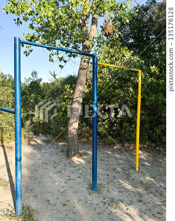 Colorful monkey bars in a sunny park for playful activities Colorful monkey bars in a sunny park for playful activities 135176128