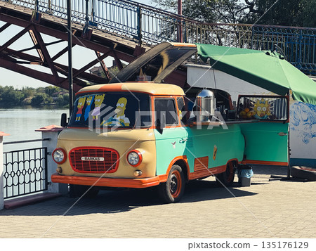 Vintage food truck by a river under a bridge. 135176129