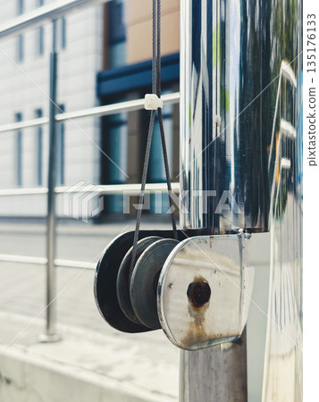 Close-up of a metallic pulley in an urban setting. 135176133