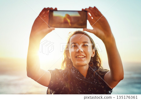 Selfie, nature and woman with smart phone or enjoying ocean or relaxed face for vacation in summer or excited on bokeh. Face, female person and taking picture or holiday fun or blue sky and sea Selfie, nature and woman with smart phone or enjoying ocean or relaxed face for vacation in summer or excited on bokeh. Face, female person and taking picture or holiday fun or blue sky and sea 135176361