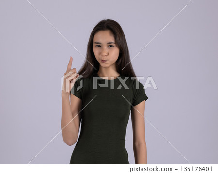 Woman in black t-shirt pointing up Woman in black t-shirt pointing up 135176401