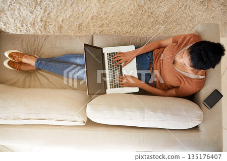 Top view of woman on couch with laptop, typing for blog and freelance copywriter working from home. Female freelancer in living room, copywriting and writing on pc with technology and remote work 135176407