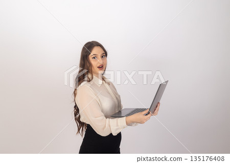 Businesswoman with laptop standing on white background 135176408