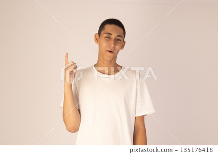 Young man holding index finger up Young man holding index finger up 135176418