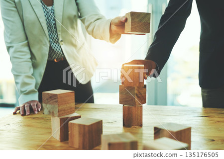 Teamwork, man and woman in office with building blocks, design ideas and problem solving challenge. Engineering, planning and strategy, wood block game and team of business people working together. Teamwork, man and woman in office with building blocks, design ideas and problem solving challenge. Engineering, planning and strategy, wood block game and team of business people working together. 135176505