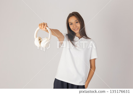 Woman in white shirt with headphones Woman in white shirt with headphones 135176631