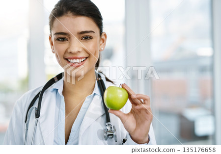 Doctor, portrait and smile of woman with apple for nutrition, healthy diet or wellness. Face, nutritionist and medical professional with fruit for vitamin c, healthcare and food for vegan benefits. 135176658