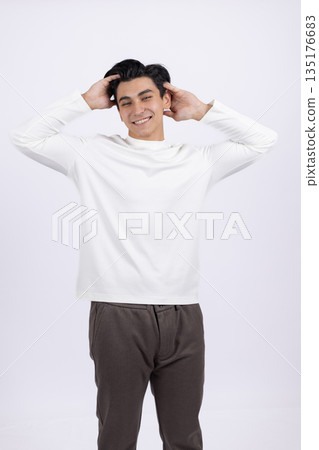 Man in a white sweatshirt touching his head Man in a white sweatshirt touching his head 135176683
