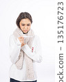 Sick woman wrapped in a white scarf holding her neck 135176723