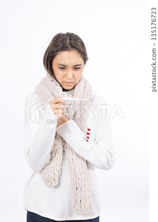 Sick woman wrapped in a white scarf holding her neck 135176723