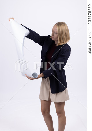 Businesswoman in a suit holding a large blueprint Businesswoman in a suit holding a large blueprint 135176729