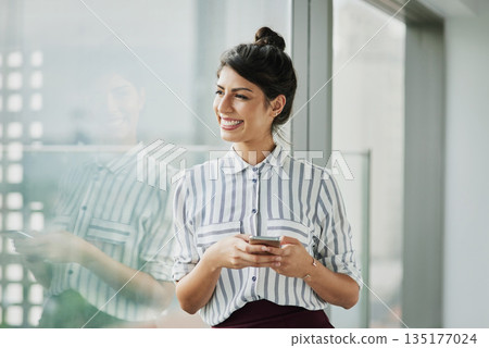 Business woman, thinking and phone with goal at office window with smile and idea. Female employee vision and mobile connection of a worker feeling happy on social media and technology at company Business woman, thinking and phone with goal at office window with smile and idea. Female employee vision and mobile connection of a worker feeling happy on social media and technology at company 135177024