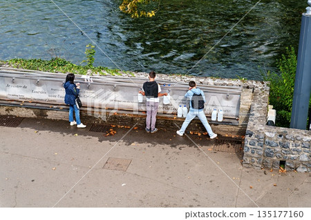 Pilgrims to the Sanctuary of Lourdes in France filling up bottle 135177160