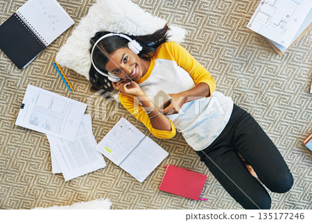 Phone music, floor and woman portrait, happy student or learner listening to audio podcast, radio or streaming sound. Education, headphones and person learning, relax and studying for college at home Phone music, floor and woman portrait, happy student or learner listening to audio podcast, radio or streaming sound. Education, headphones and person learning, relax and studying for college at home 135177246