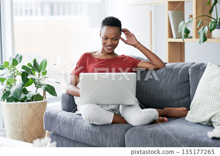 Happy, black woman and relax with laptop on a sofa, comfortable and chilling on the weekend. Streaming, smile and African female person online for internet, search and subscription in a living room 135177265