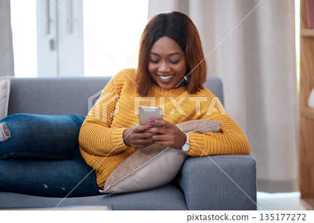Black woman with smartphone, chat on social media and relax at home, smile with online communication. African female person, mobile app with text message or post update with connectivity in apartment Black woman with smartphone, chat on social media and relax at home, smile with online communication. African female person, mobile app with text message or post update with connectivity in apartment 135177272