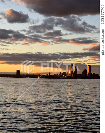 Stunning Sunset Over City Skyline Reflected in Water Stunning Sunset Over City Skyline Reflected in Water 135177765