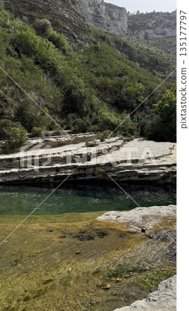 Serene Natural Pool Surrounded by Lush Greenery in Greece Serene Natural Pool Surrounded by Lush Greenery in Greece 135177797
