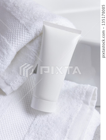 White cosmetic squeeze tube on white bath towel and basin close up, cosmetic mockup White cosmetic squeeze tube on white bath towel and basin close up, cosmetic mockup 135178085