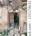 A wooden door is open in front of a stone wall 135178632