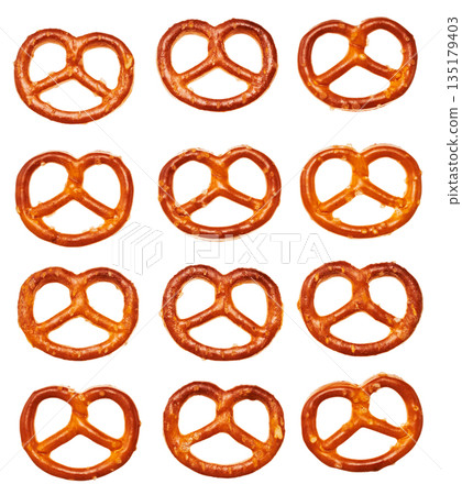 A grid pattern of mini pretzels arranged on a white background. Snacks and snacks. 135179403