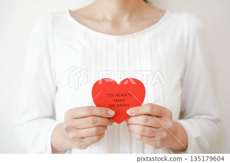 Woman holding a heart message card 135179604