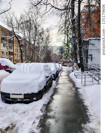 Cars Covered in Thick Snow After Blizzard in Residential Courtyard 135179606