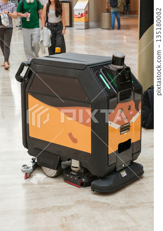 Robotic cleaning machine on display in Changi Airport Singapore with travelers in background Robotic cleaning machine on display in Changi Airport Singapore with travelers in background 135180082