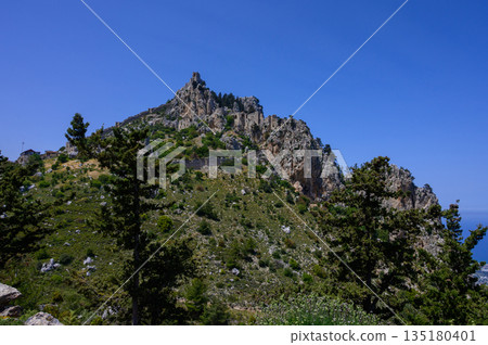 Ancient walls and towers of St. Hilarion Castle, an iconic historical site perched on a mountain in Cyprus. 135180401