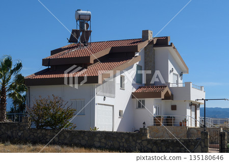 Charming hillside villa with panoramic views and a contemporary design nestled in nature under a clear blue sky 135180646