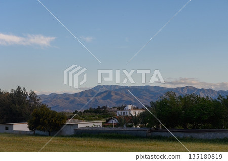 Breathtaking mountain landscape at dusk with serene countryside and lush greenery in tranquil setting 135180819