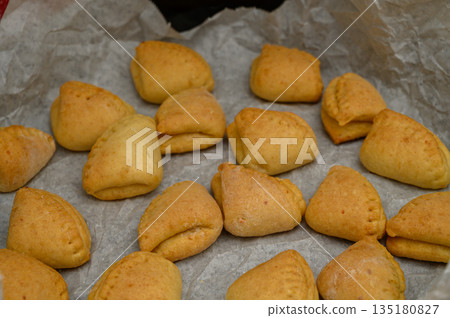 Warm "Goose Feet" Cookies with Icing Sugar on Baking Paper 135180827