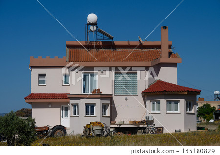 Bright afternoon light illuminates a unique home with scenic surroundings and agricultural elements in the countryside 135180829