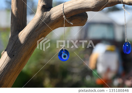 Vibrant blue talismans sway gently on a sunlit afternoon, offering protection and charm among nature's embrace 135180846