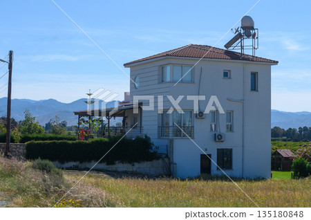 Charming countryside house with satellite dish nestled among green fields on a clear sunny day Charming countryside house with satellite dish nestled among green fields on a clear sunny day 135180848