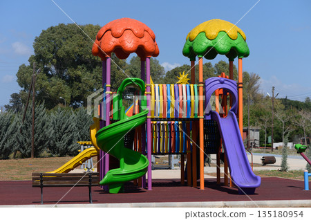 Vibrant playground structure invites children for adventure and imaginative play in a sunny park setting Vibrant playground structure invites children for adventure and imaginative play in a sunny park setting 135180954
