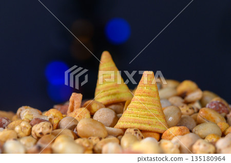 Colorful snack pyramids stand proudly atop a mound of crunchy treats in a festive and playful display Colorful snack pyramids stand proudly atop a mound of crunchy treats in a festive and playful display 135180964
