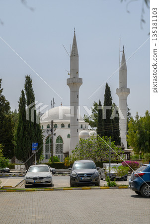 Majestic mosque towers rise against a bright blue sky in a tranquil urban park setting during midday hours Majestic mosque towers rise against a bright blue sky in a tranquil urban park setting during midday hours 135181103