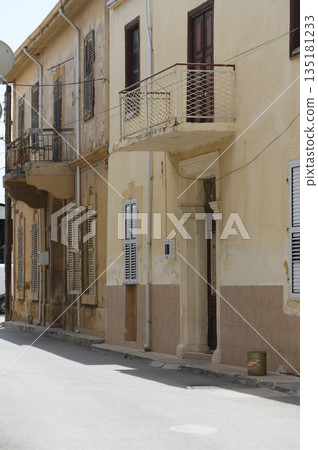 Vintage architecture stands time in a quiet street of an old town, showcasing blend of history and charm in its weather Vintage architecture stands time in a quiet street of an old town, showcasing blend of history and charm in its weather 135181233